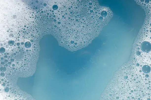 closeup to white foam on blue water