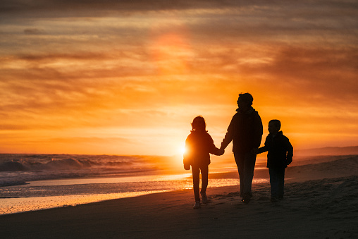 Family walk by the Hamptons Beach at sunset