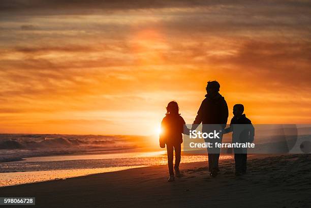 Family Walk By The Beach At Sunset Stock Photo - Download Image Now - Family, In Silhouette, Sunset