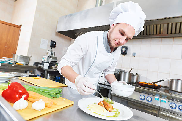 istock male chef decorating food plate 598067990