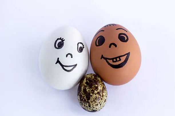 Photo of Funny eggs imitating a happy mixed couple with multicolored baby