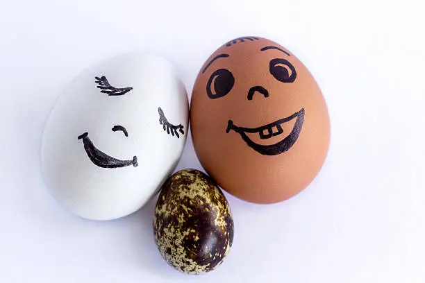 Photo of Funny eggs imitating a smiling mixed family with versicolored baby