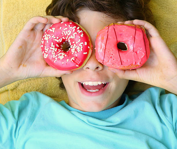 istock preteen boy with doughnut glasses close up 598071662