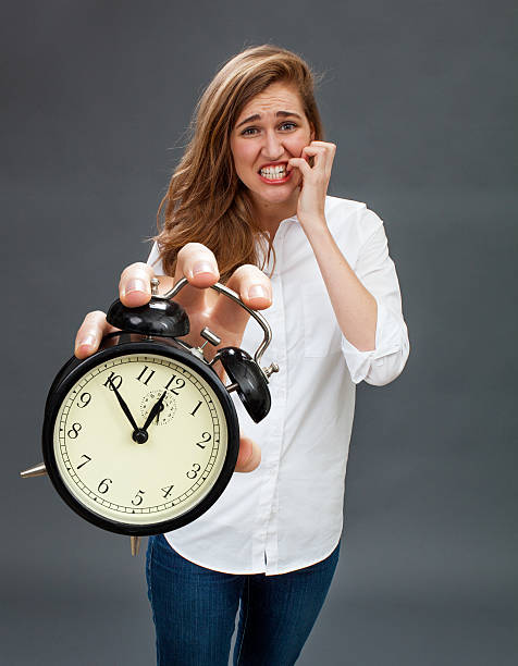 istock scared beautiful woman showing stressful alarm clock for worrying deadlines 598073420