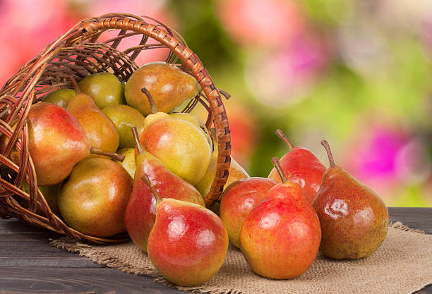istock pears in a wicker basket on wooden table with blurred 598074886