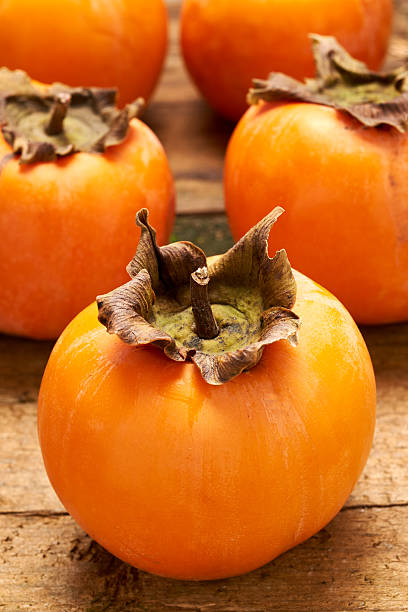 istock Yummy persimmon on a wooden board 598077618