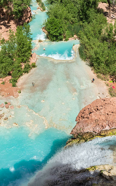 Havasu Falls and Havasu Creek Havasu Creek plunges 100 feet over a travertine cliff  into a pure turquoise pool on the Havasupai Indian Reservation in the Grand Canyon. harasu canyon stock pictures, royalty-free photos & images