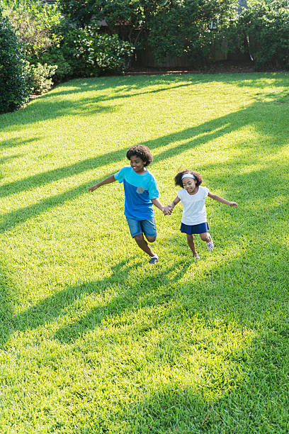 istock Mixed race brother and sister playing in park 598078254