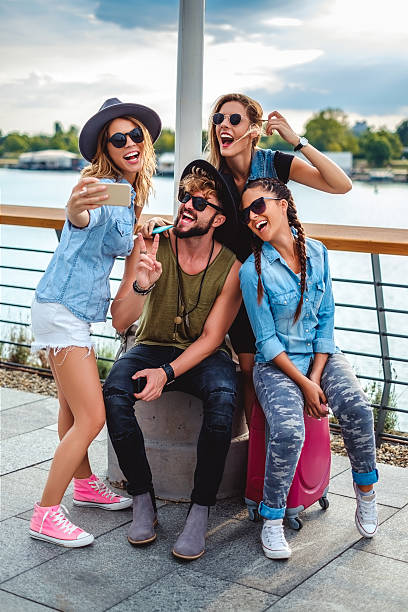 istock Group of tourists taking selfie by the river 598080110