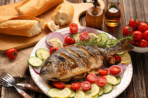 istock Grilled fish with baguette and vegetables on the plate 598081512