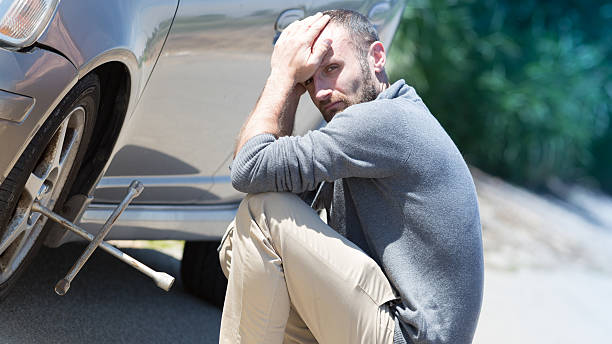 istock Unhappy man repairing a tire 598082370