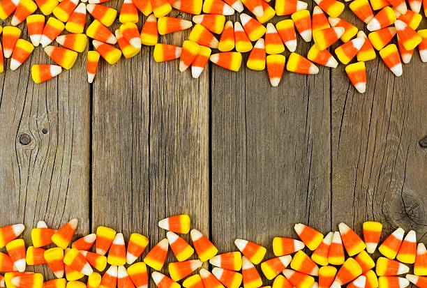 Halloween candy corn double border over old wood Halloween candy corn double border against a rustic wood background candy corn stock pictures, royalty-free photos & images