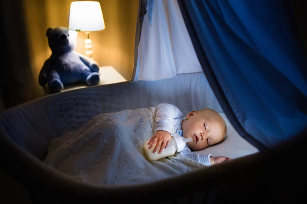 istock Baby boy drinking milk in crib 598083292