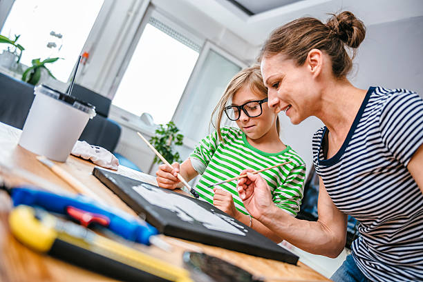 istock Mother and daughter painting canvas 598083492