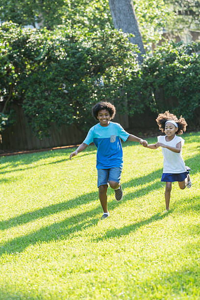istock Mixed race brother and sister running in park 598083592