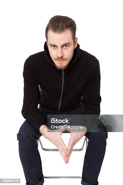 Macho Man In A Black Sweater Stock Photo - Download Image Now - Men, Sitting, 20-29 Years