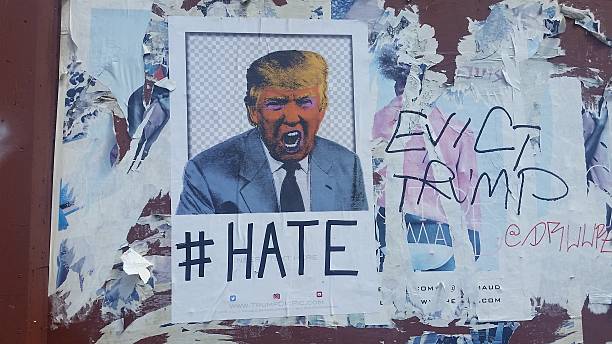 Political Viewpoints of Donald Trump in USA Before Presidential Elections New York City, United States - June 29, 2016: In the months leading up to the presidential election on the exterior of a building in the Chelsea neighborhood of Manhattan a poster with an image of Donald Trump is posted with the caption "# Hate". Someone has written on top of old peeling posters besides it "Evict Trump". 2016 stock pictures, royalty-free photos & images