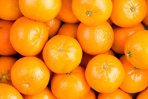 Food background of healthy ripe clementines Food background of fresh healthy ripe orange clementines, tangerines or mandarins in a full frame view rich in vitamin c orange fruit stock pictures, royalty-free photos & images
