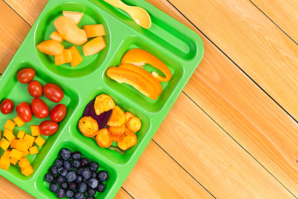 istock Child size lunch tray with fruit on wooden table 598086474