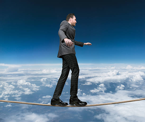 istock Businessman balancing on tightrope with stormy day 598086968