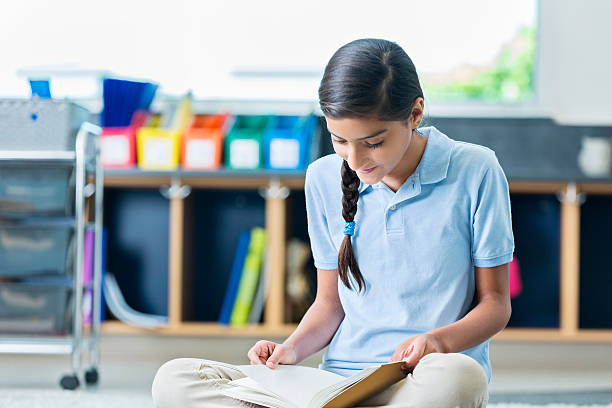 istock Cute schoolgirl studies in the library 598087832