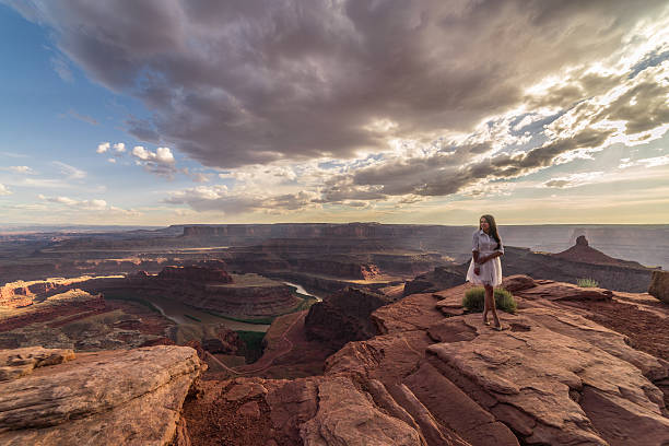 istock Asian bride posing over vast canyons of Utah desert, Moab. 598087954