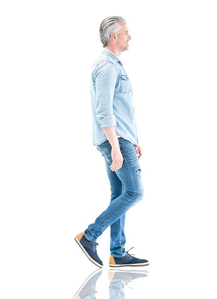 Casual man walking to the side Casual adult man in denim clothes walking to the side - isolated over a white background man standing profile stock pictures, royalty-free photos & images