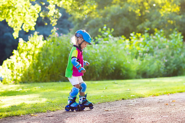 istock Kids roller skating in summer park 598090670