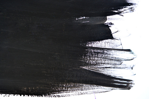 black brush strokes on white paper with one hand isolated