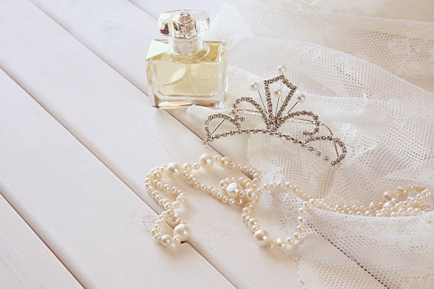 istock White pearls necklace, diamond tiara and perfume bottle 598092114