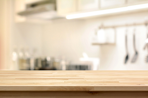 Mesa de madera (isla de la cocina) en el fondo interior de la cocina desenfoque photo