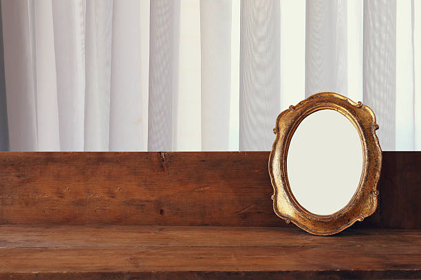 istock Golden old blank frame on wooden window sill 598092492
