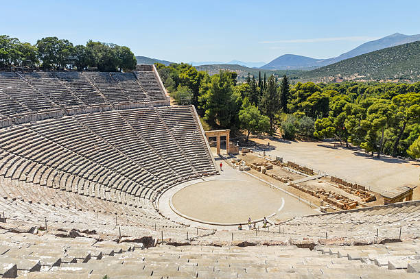 Ancient Theater of Epidaurus in Greece Epidaurus, Greece - June 12, 2016: Tourists visit the Ancient Theater of Epidaurus. Photo taken during a hot summer day. greek amphitheater stock pictures, royalty-free photos & images