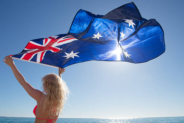istock Attractive woman Australian flag at ocean 598099136