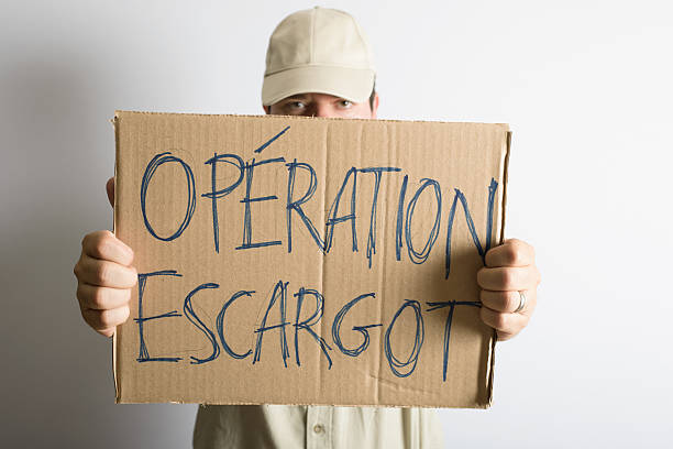 istock Man Holding Strike Action Sign Reading Operation Escargot 598099756