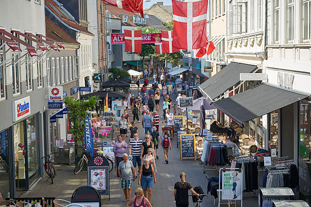 Odense, Denmark - August 26, 2016: Tourists and local people enjoy a sunny summerday in the pedestrian street Vestergade.