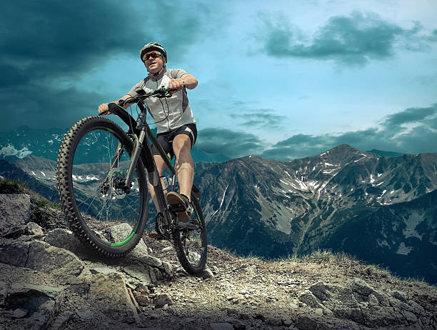 istock Man stay on the bicycle under sky with clouds. 598133170