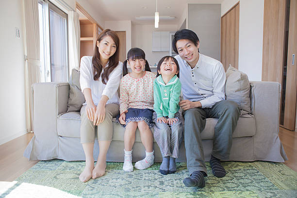japanische familie sitzt auf dem sofa - japan fotos stock-fotos und bilder
