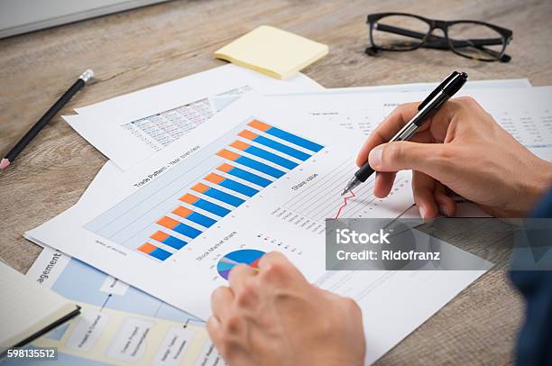 Businessman Analyzing Graphs Stock Photo - Download Image Now - Financial Report, Reading, Achievement