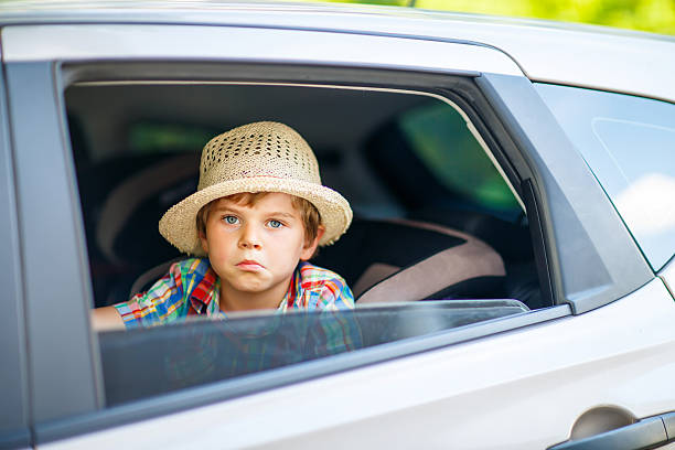 istock Sad tired kid boy sitting in car  during traffic jam 598139886