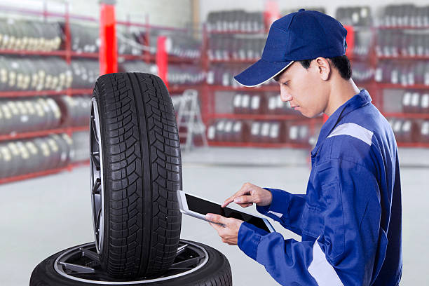 istock Male mechanic with tires and tablet 598141106