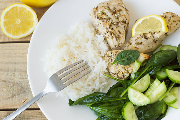 Baked chichen breasts with lemon, white rice and green spinach