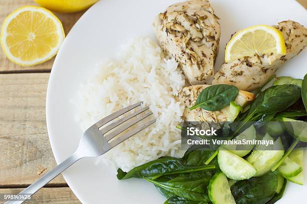 Baked Chichen Breasts With Lemon White Rice And Green Spinach Stock Photo - Download Image Now