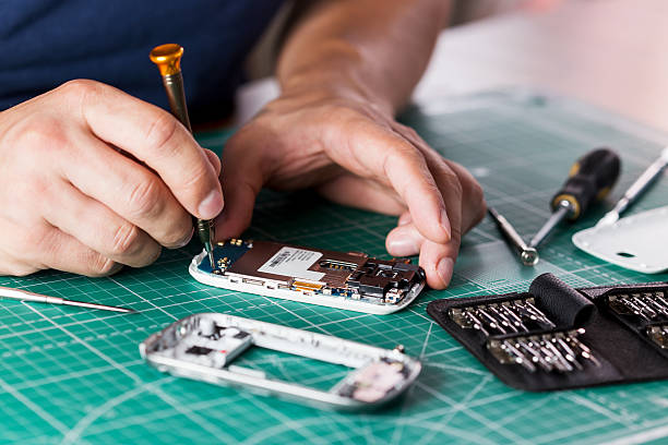 istock Man repairing broken smartphone, close up photo 598143328