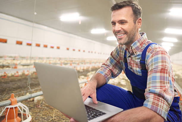 landwirt mit laptop in der landwirtschaft - farmer rural scene laptop computer stock-fotos und bilder