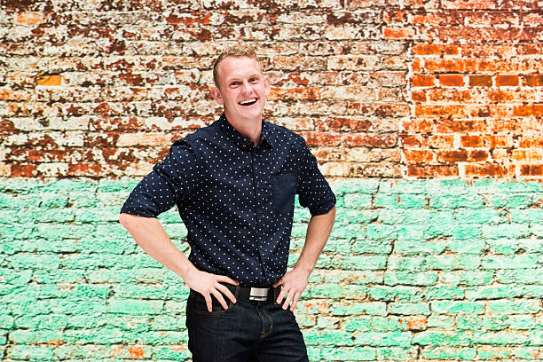 istock Cheerful man standing in front of brick wall 598144520