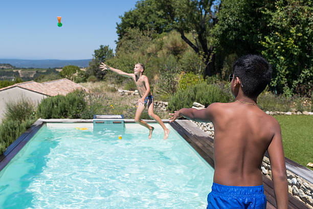 istock Boys playing in a swimming pool 598146402