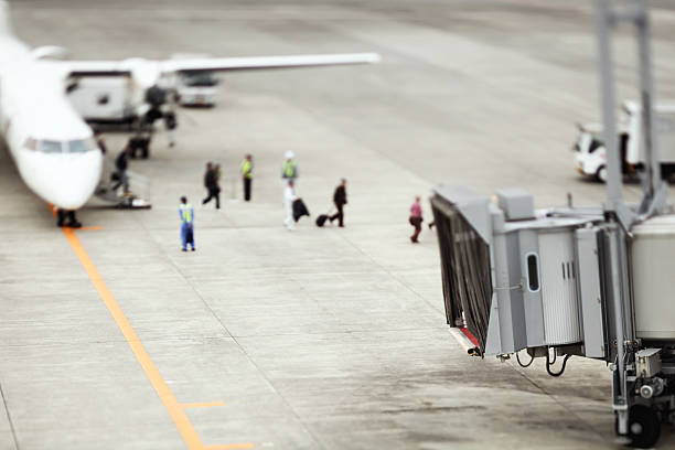 istock Passengers walking down stairs at airplane and walking to terminal 598148252