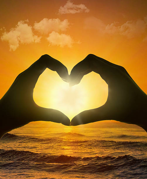 istock Hands of Heart shape with sea and sky sunset 598149680