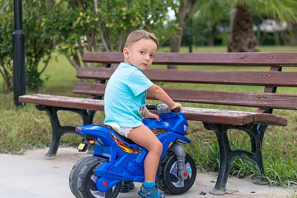 Little baby boy riding on the blue motobike